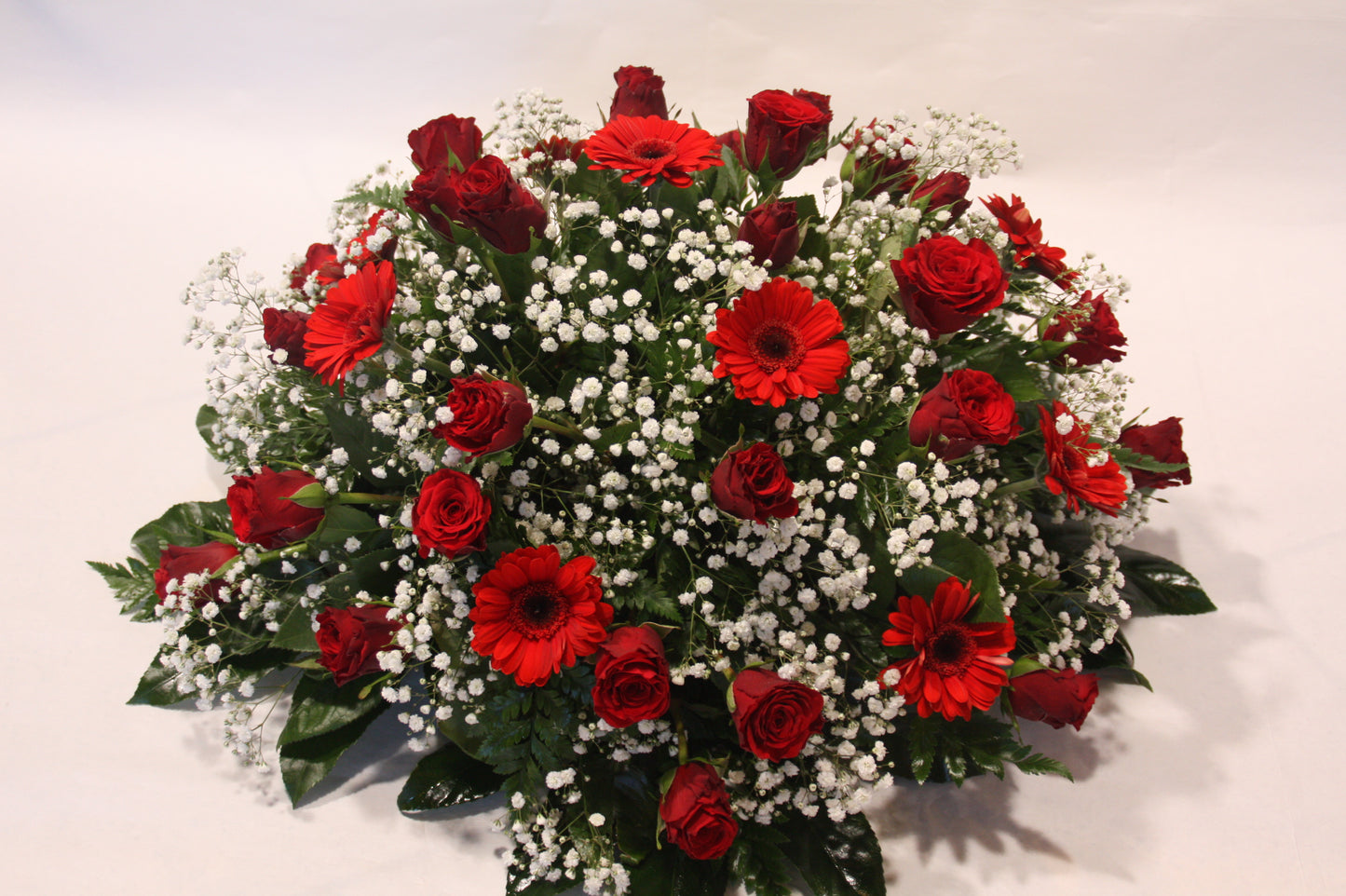 Rouwstuk roos en gerbera's rood-wit